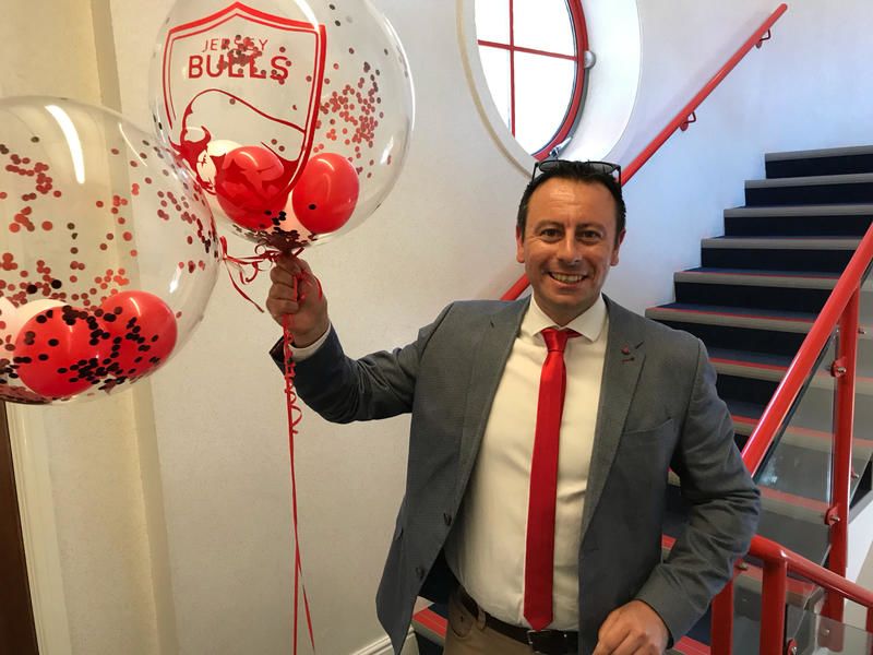 Ian Horswell holds Jersey Bulls branded balloons.