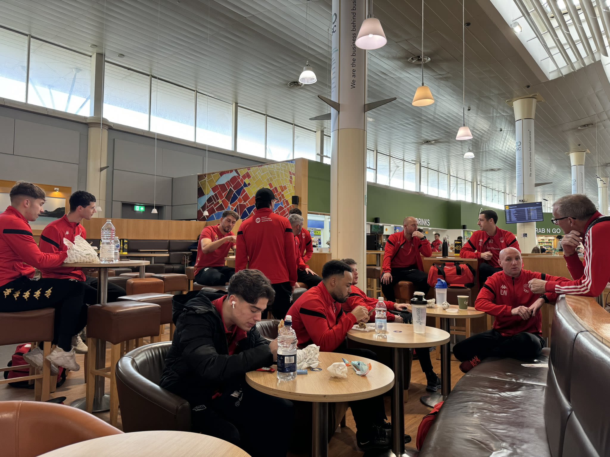 Jersey Bulls players wait in the cafe area at Jersey Airport.